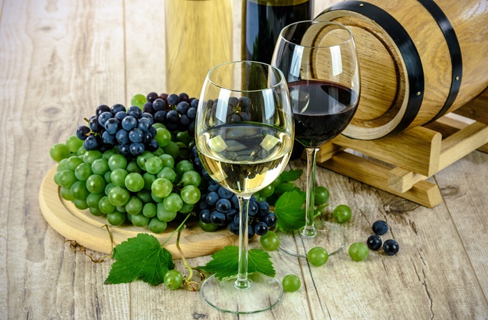 Zwei Weingläser mit Weintrauben im Hintergrund
