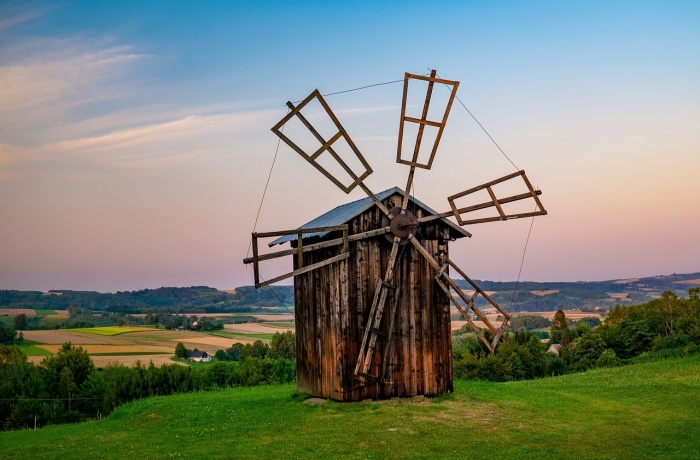 Natur von Polen mit brauner Holzwindmühle auf einer Wiesenlandschaft