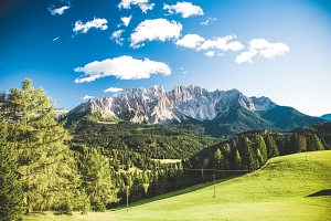 Reisetrends 2024: Man blickt auf eine frühlingshafte Berglandschaft in den Dolomiten