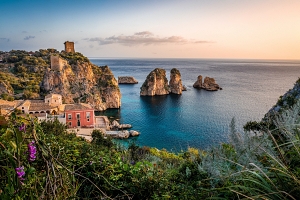 Man blickt über die Bucht von Scopello in Sizilien, in der unteren Bildhälfte befindet sich die "Tonnara", die alte Thunfisch-Fangstätte des Ortes, an der man heute baden kann